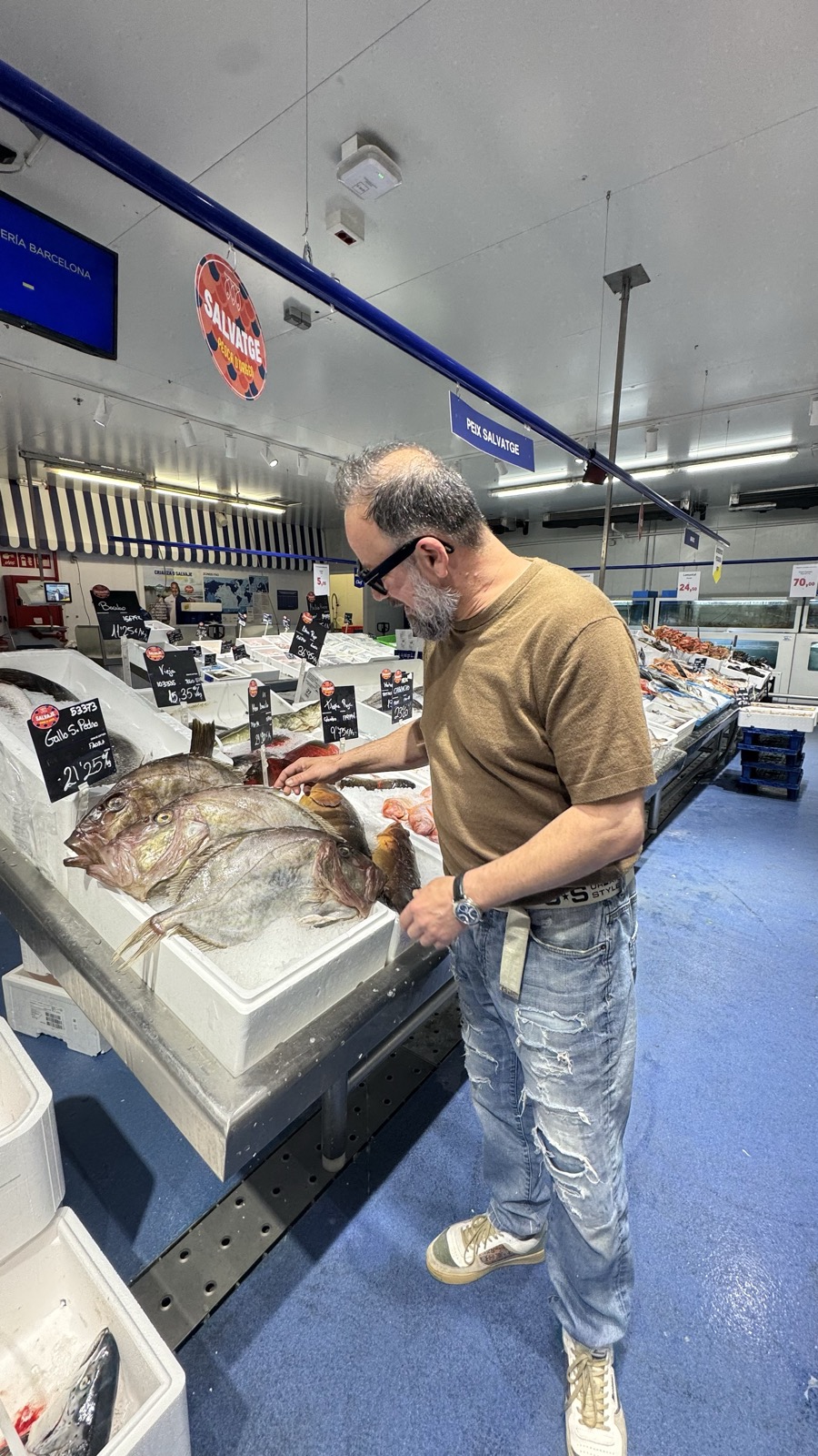 Frank triant peix fresc en un mercat de Barcelona